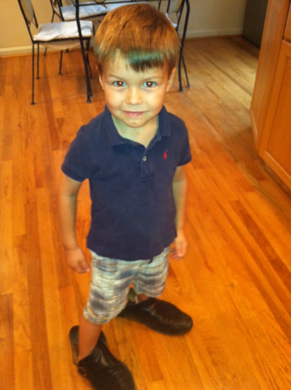 little boy wearing big shoes